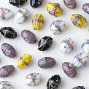 Detalle macro de cuentas de vidrio lampwork hechas a mano con líneas doradas
