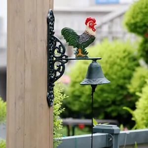 Detailed view of vintage cast iron rooster doorbell mounted on a rustic wooden pillar