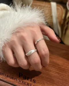 Close-up view of a minimalist S925 sterling silver wave ring with brushed texture