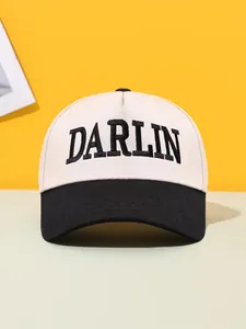Close-up detail of DARLIN embroidery on a stylish two-tone beige and black baseball cap