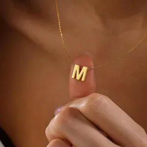 Primer plano de un collar con colgante de letra M en acero inoxidable bañado en oro 18k
