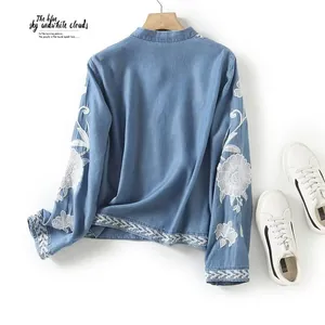 Detailed view of a blue Tencel shirt featuring intricate white floral embroidery on the sleeves.