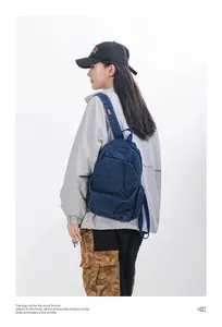 Vista detallada de una mujer con una mochila pequeña de mezclilla azul oscuro lavada