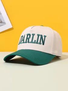 Close-up of green DARLIN embroidery on beige and green color-block trucker hat