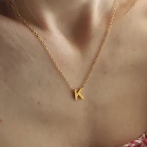 Primer plano del collar minimalista de acero inoxidable chapado en oro de 18k con K
