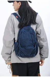 Vista trasera de una mochila pequeña de mezclilla lavada en una modelo mujer