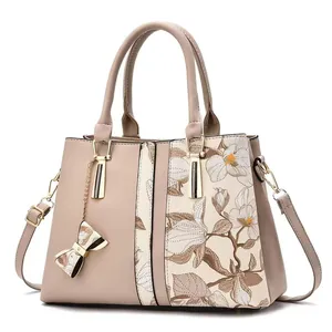 Elegante bolso de mano con estampado floral, colgante de lazo y detalle de cuero sintético