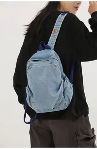 Imagen detallada de la vista trasera de una mini mochila de mezclilla lavada vintage en una modelo