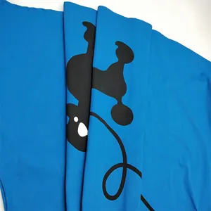 Détail d'un tissu bleu de style vintage avec un imprimé caniche noir.