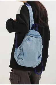 Mochila pequeña de mezclilla lavada vintage para mujer llevada por una modelo casual