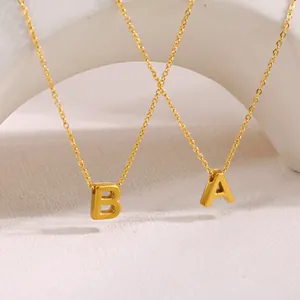 Detalle de los collares con iniciales 'A' y 'B' en acero de titanio chapado en oro 18k