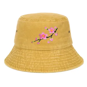 Detailed view of yellow bucket hat featuring delicate cherry blossom embroidery