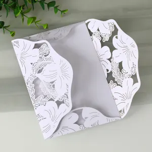 Close-up of elegant white laser-cut floral wedding invitation card with intricate detail