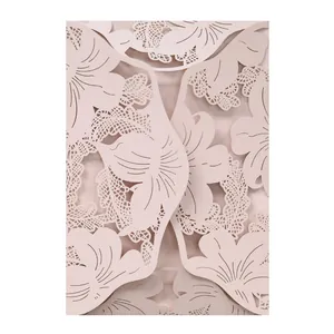 Close-up detail of an elegant light pink laser-cut floral pattern wedding invitation card