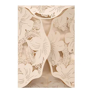 Close-up of elegant champagne laser-cut hollow floral lace wedding invitation card