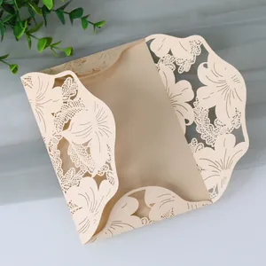 Detail of elegant laser-cut floral pattern on champagne wedding invitation card