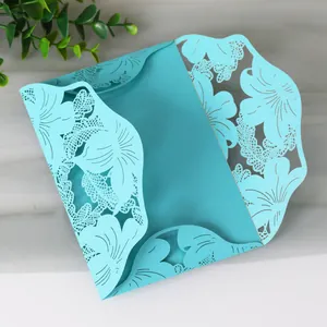 Intricate laser-cut blue wedding invitation card with elegant floral patterns.