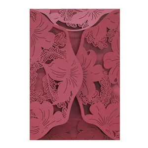 Detailed view of intricate laser-cut floral patterns on elegant burgundy invitation card