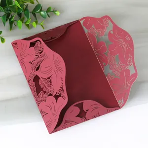 Detailed view of an elegant burgundy laser-cut floral pattern wedding invitation card