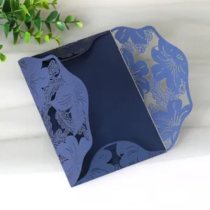 Detailed view of intricate laser-cut floral patterns on a navy blue invitation card.
