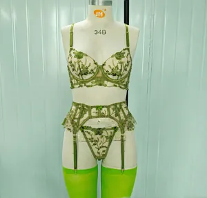 Vista macro del ricamo floreale verde su set lingerie in rete di lusso