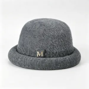 Detailed view of grey winter knit bucket hat with fuzzy texture and elegant gold M logo