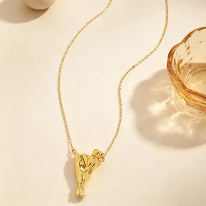 Primo piano di una collana dorata con un ciondolo porta fiori dal design artistico unico