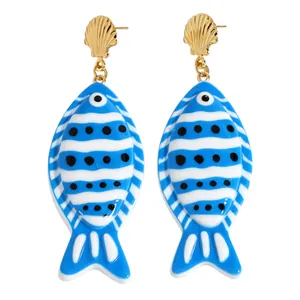 Détail de boucles d'oreilles poissons tropicaux rayés avec un fermoir en coquille dorée