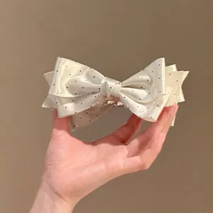 Élégante pince à cheveux en satin blanc à pois noirs avec un design de nœud