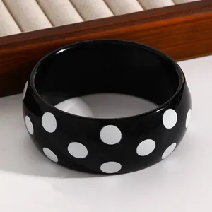Chunky black resin bangle with white polka dots, stylish vintage jewelry for women