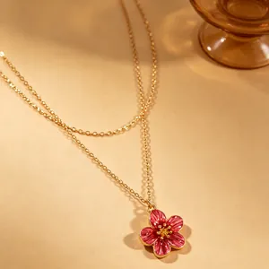 Exquisite close-up of pink enamel flower pendant on a golden double-layer chain
