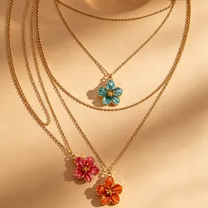 Close-up of colorful flower enamel pendants on delicate gold chains