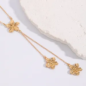 Close-up of golden flower pendants on a delicate chain for a sweet vacation look