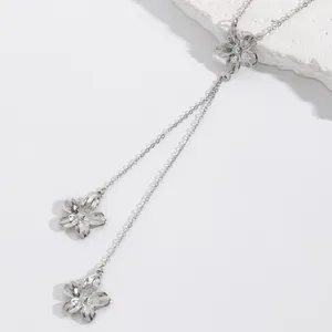 Detailed macro view of silver-toned flower pendants on a delicate lariat necklace