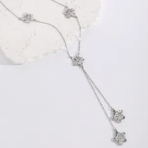 Detailed macro view of silver flower charms on a delicate metal necklace chain