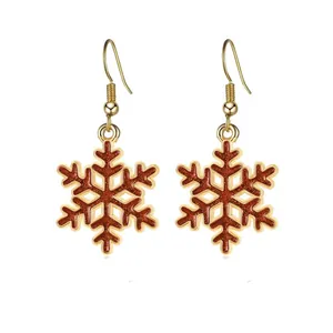 Nahaufnahme roter Glitzer-Schneeflocken-Ohrringe mit Goldfinish für Weihnachten