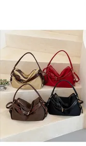Detail view of four minimalist canvas shoulder bags in various colors on stone steps