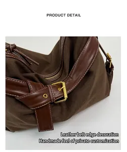 Detail view of brown canvas bag featuring leather strap and gold-tone buckle