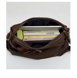 Interior view of brown canvas crossbody bag showing spacious capacity with books