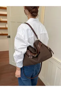Stylish brown canvas and leather crossbody bag for women with retro buckle details