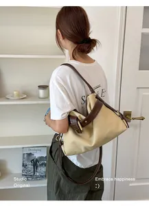 Elegant canvas and leather shoulder bag for women in a stylish minimalist setting