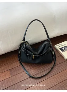 Black canvas minimalist shoulder bag with white stitching and gold hardware accents