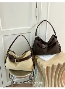 Two minimalist canvas shoulder bags with buckle detail shown in an aesthetic home setting