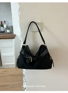 Detail shot of black minimalist shoulder bag hanging on a light wall in a modern kitchen.