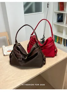 Detailed view of fashionable canvas shoulder bags in brown and red for women.