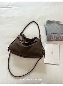 Brown minimalist canvas shoulder bag displayed with a tablet for size comparison