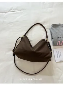 Minimalist brown canvas shoulder bag with leather strap shown from a top-down view