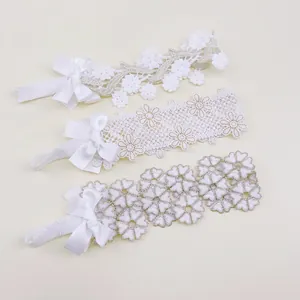 Detailed view of three white lace children's headbands with elegant flower patterns