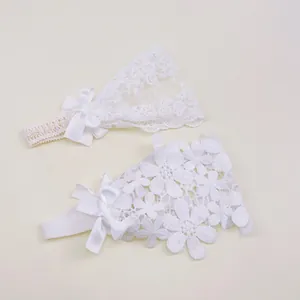Detailed view of white floral lace headbands with delicate satin bows for baby girls