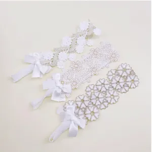 Detailed view of three white lace baby girl headbands featuring hollow flowers and bows.